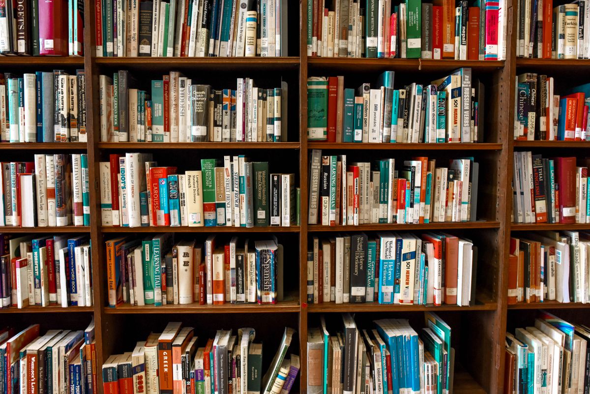 Floor-to-ceiling wooden shelves packed with books — your Previously library works the same way, one personal collection