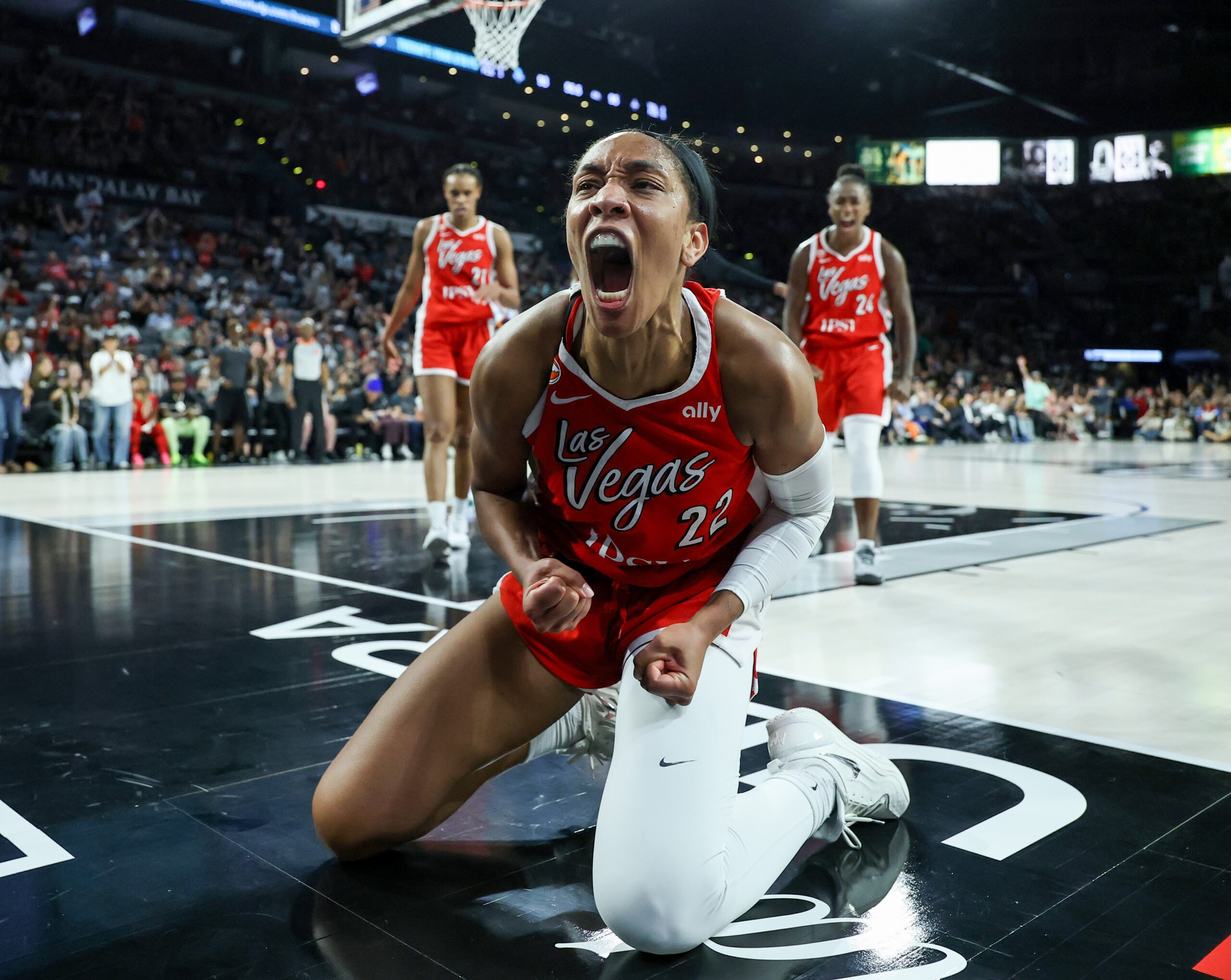 A'ja Wilson celebrates on the court in her red Las Vegas Aces jersey