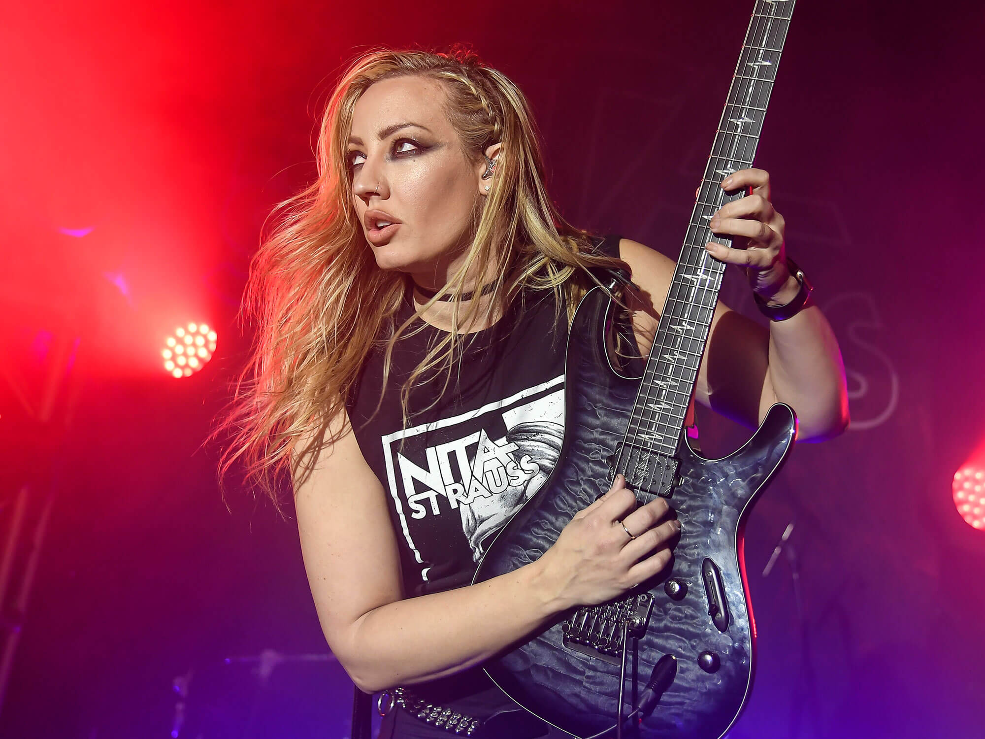 Guitarist Nita Strauss performing on stage.