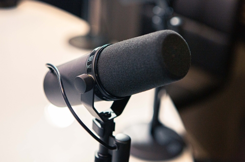 A professional podcast microphone in a bright studio