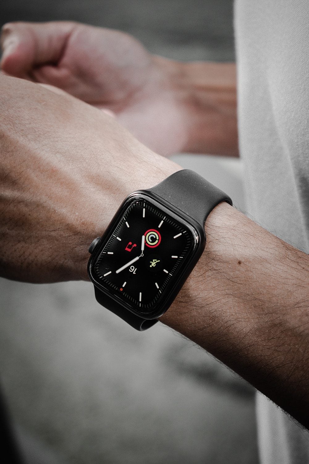 An Apple Watch on a wrist, its health and heart-rate display glowing