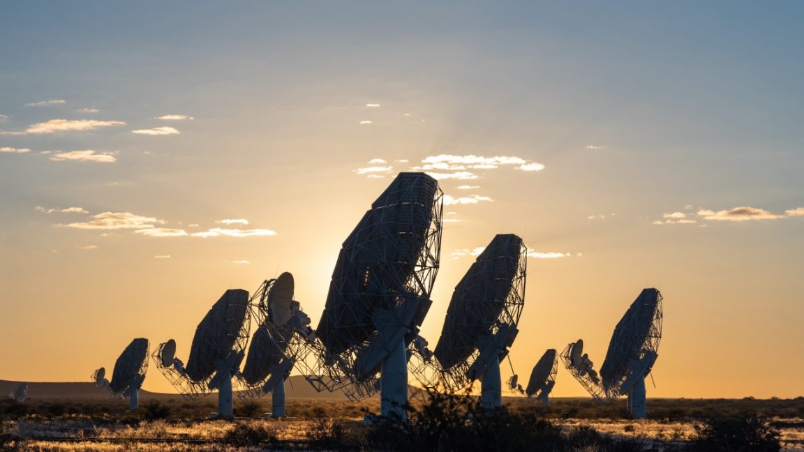 Radio telescope dishes under a wide sky