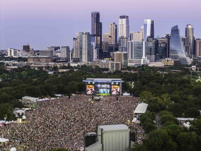 A packed crowd in front of the American Express stage at Austin City Limits, the Austin skyline beyond