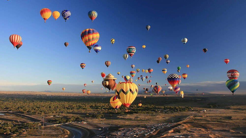 Balloons drift over the Rio Grande Valley beneath clear desert skies