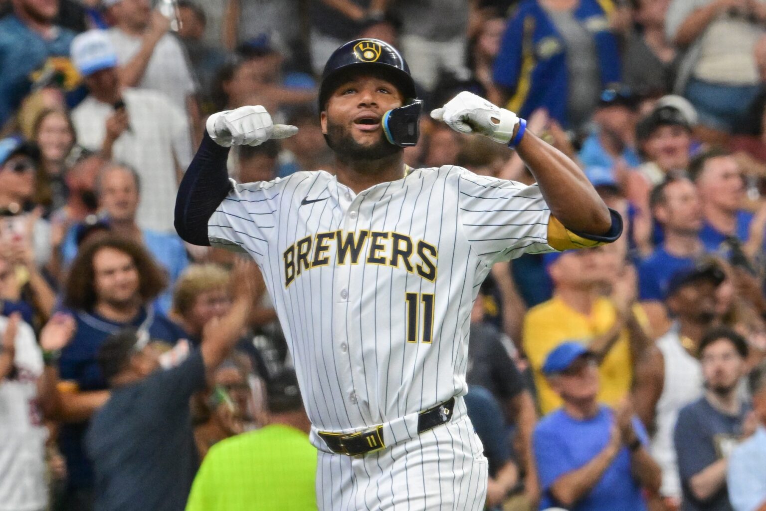 Milwaukee Brewers outfielder Jackson Chourio (11) celebrates a big moment in the white pinstripe home uniform.