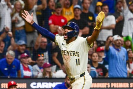 Jackson Chourio (11) of the Milwaukee Brewers celebrates with his arms raised at American Family Field.