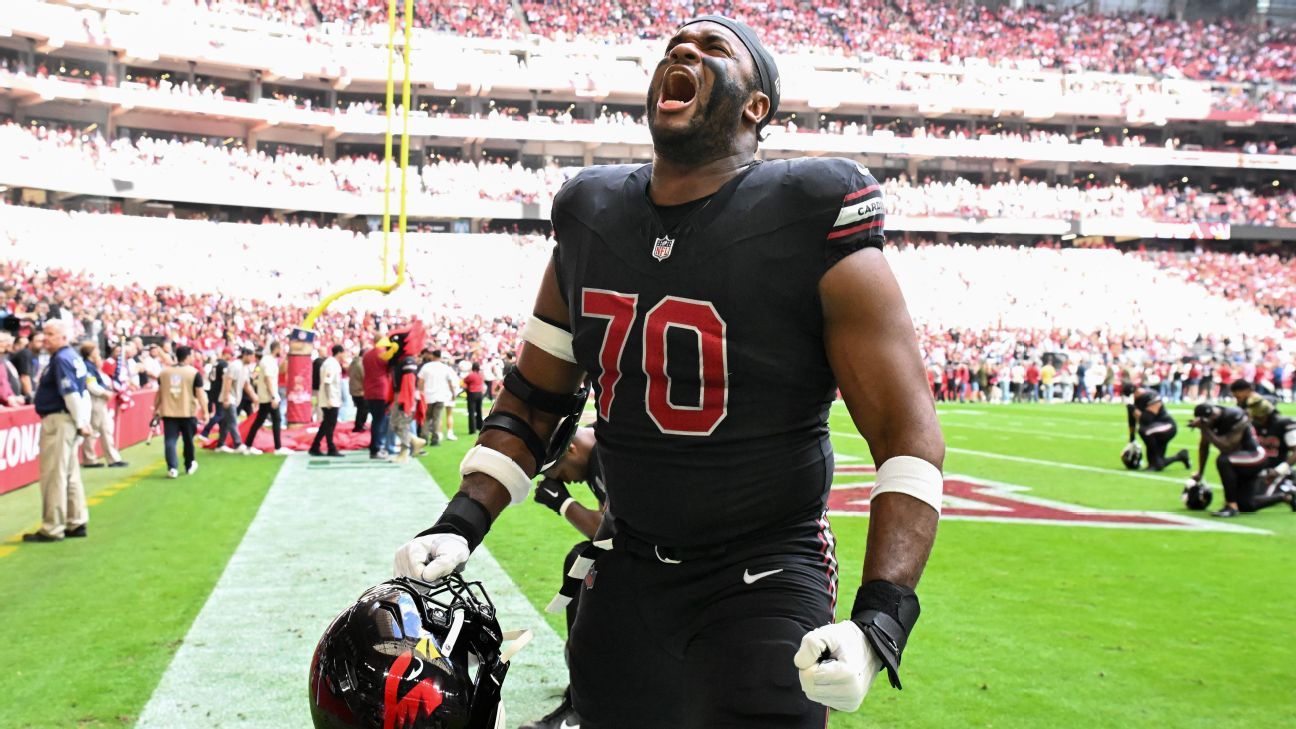 Paris Johnson Jr. celebrating in a Cardinals black jersey — the Arizona left tackle tore his left biceps Sunday and is out for the season