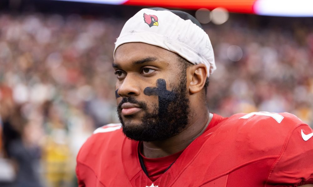 Paris Johnson Jr. on the sideline in a Cardinals red jersey