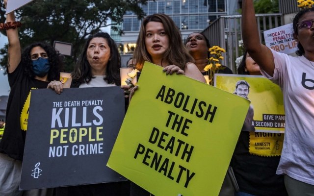 Peaceful protesters holding signs outside a government building.