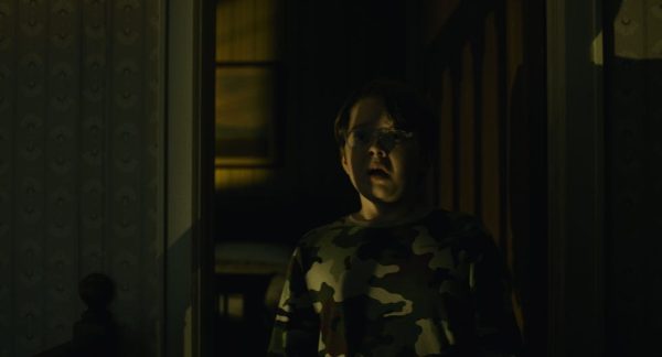 A frightened child in a doorway in a still from The Exorcist: Martyrs