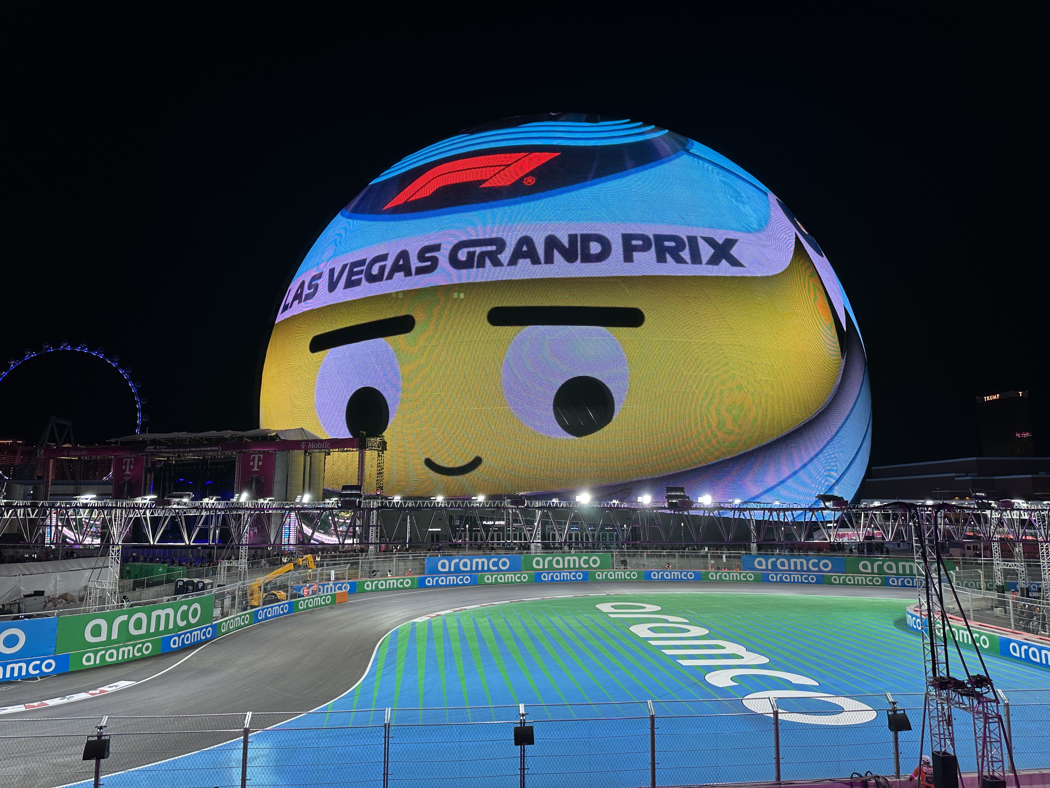 Formula 1 cars racing at night at the Las Vegas Grand Prix near the Sphere