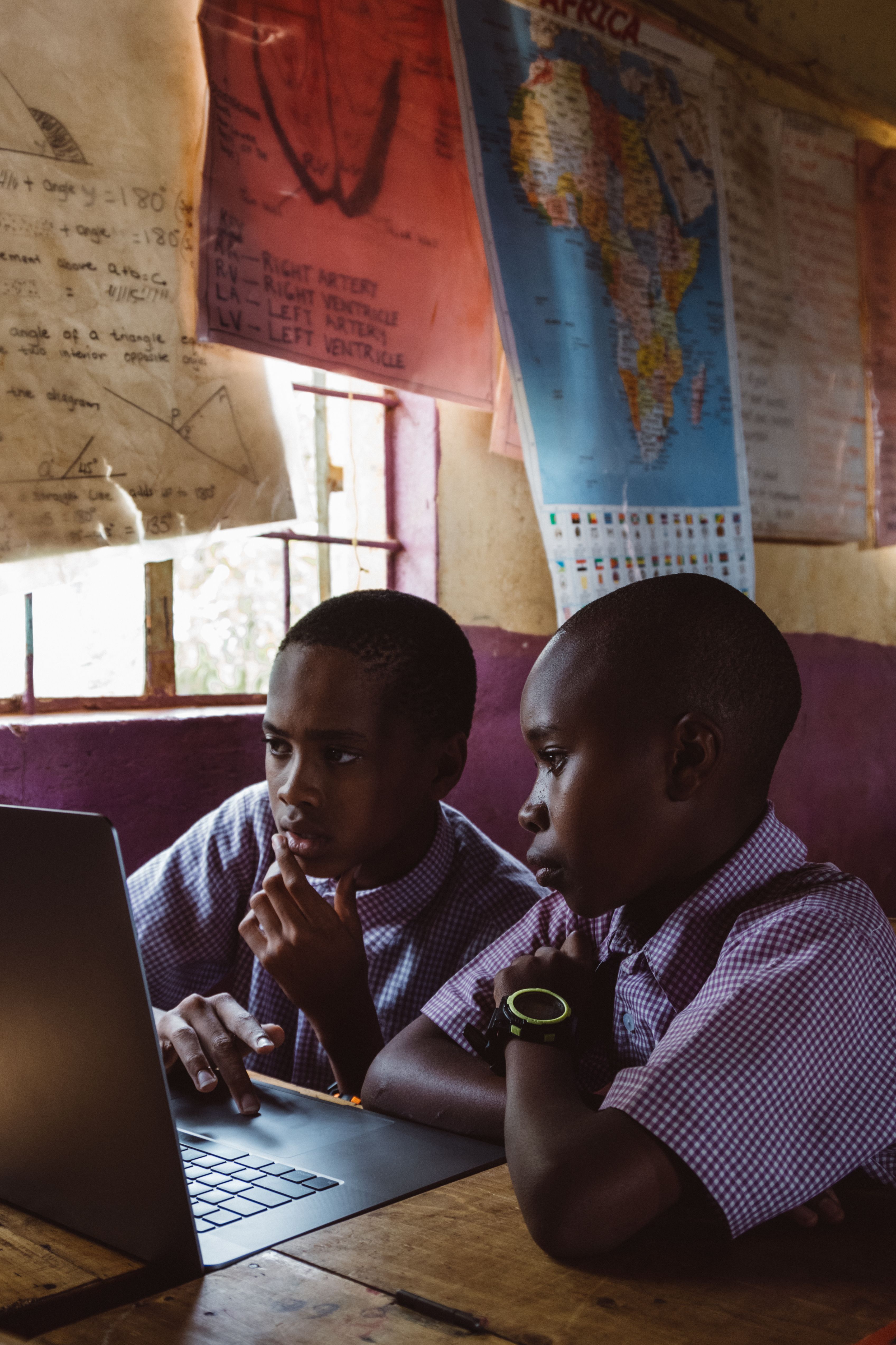 Two students sharing a laptop in a classroom