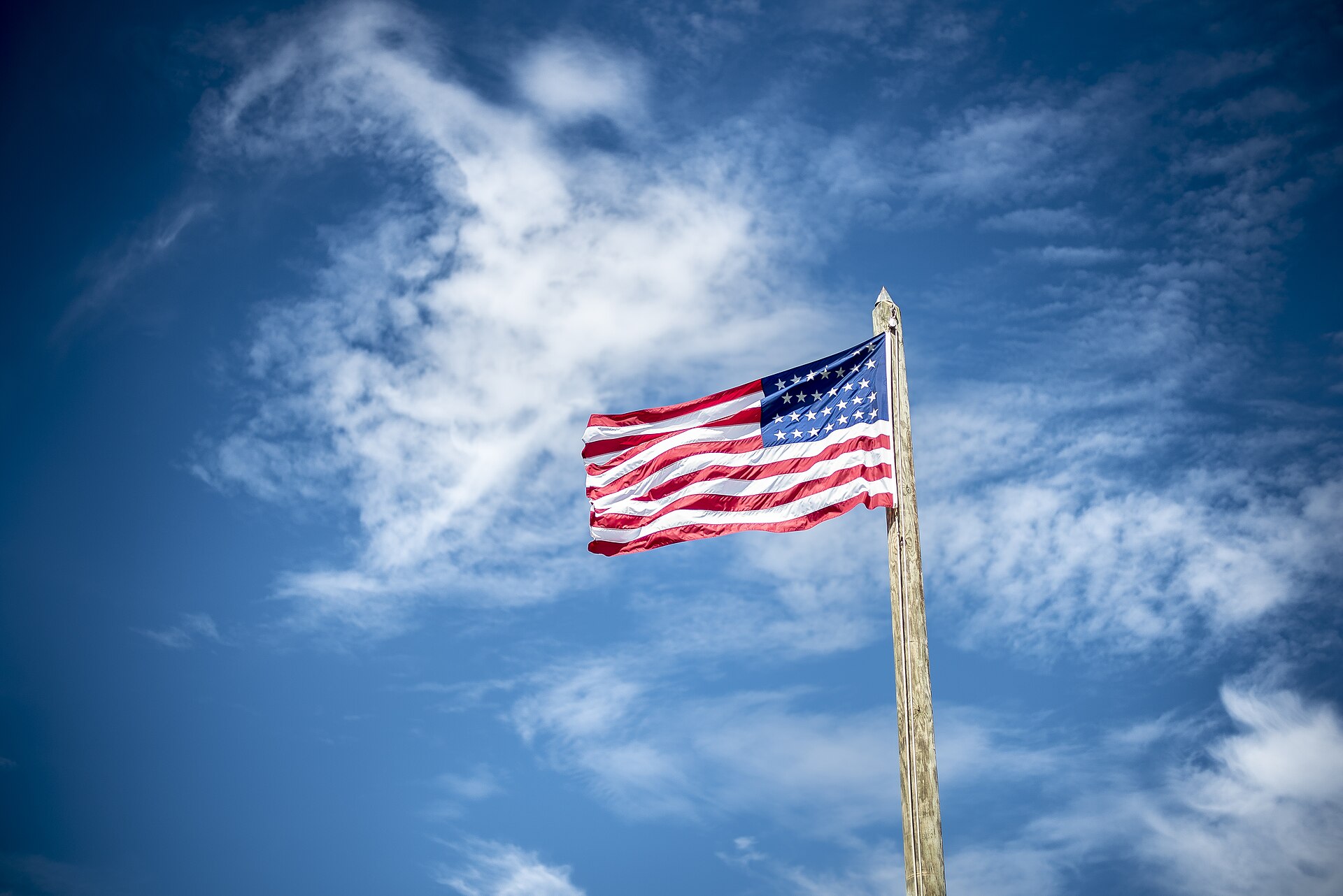 An American flag flying against a bright blue sky