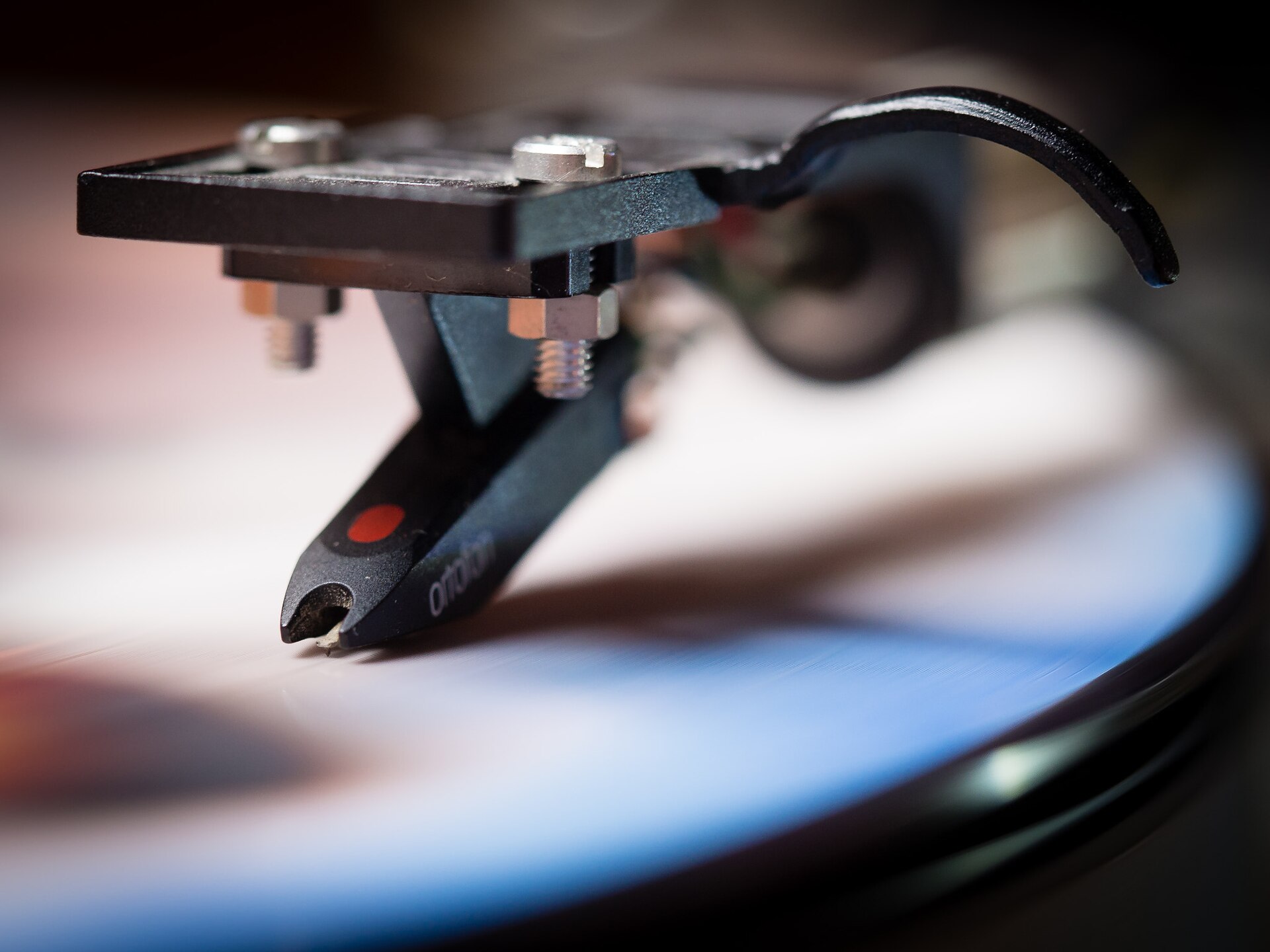 A close-up of a turntable stylus riding a vinyl record groove