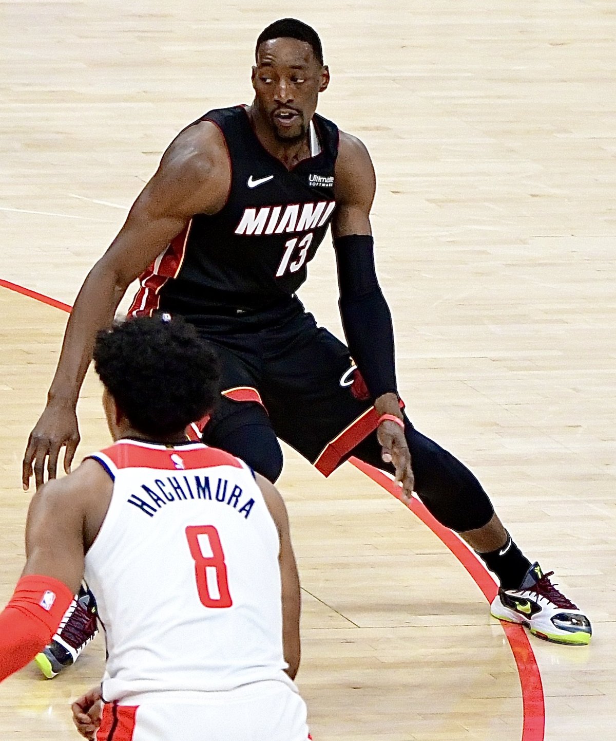 Bam Adebayo in the black Miami Heat uniform defending against Rui Hachimura