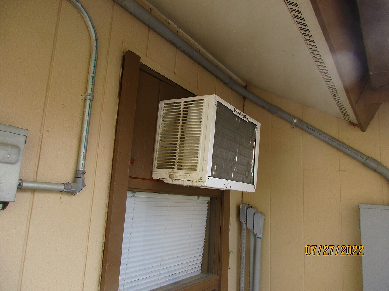 A window air-conditioning unit on a sunny day
