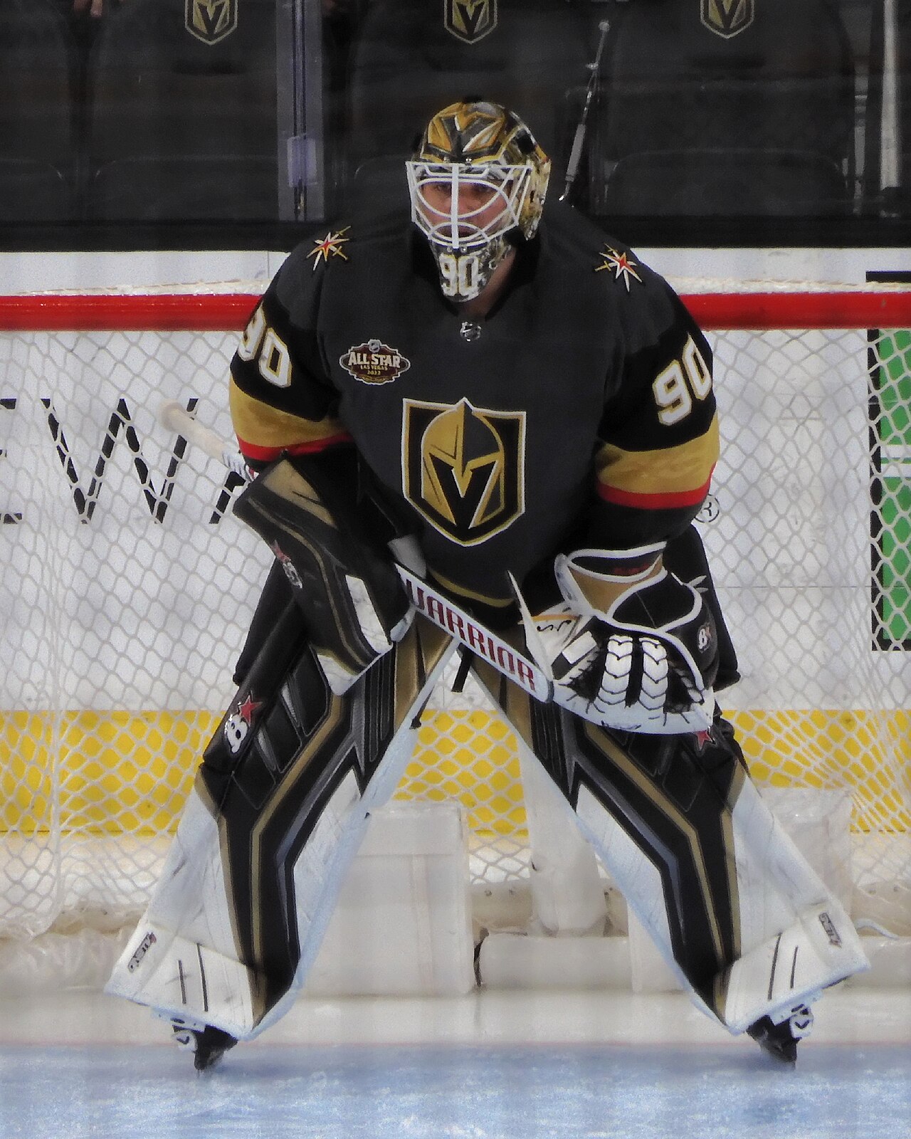 A Vegas Golden Knights goaltender in gold gear defending the net during a game