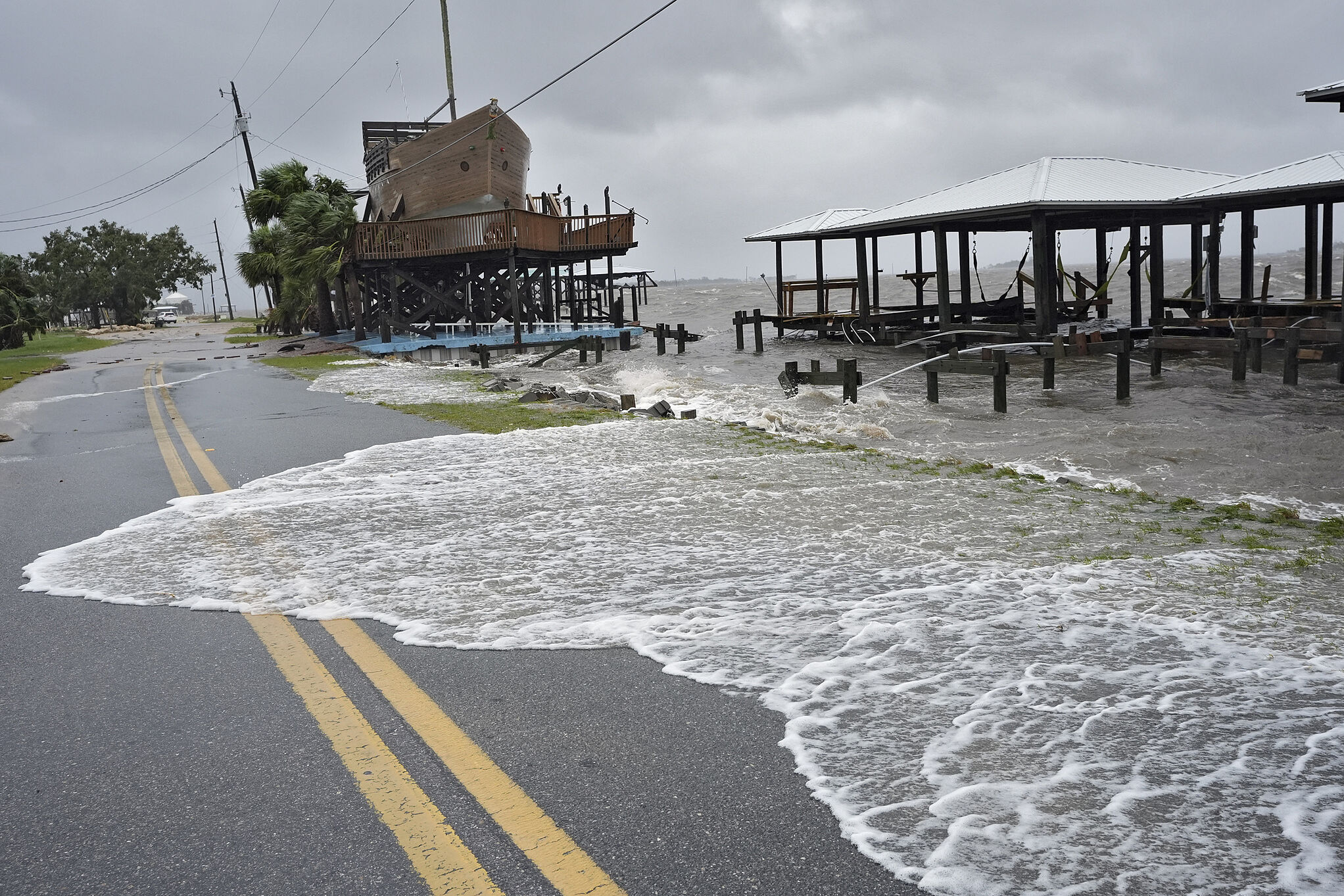 Storm surge flooding pushes water across a coastal road during a past Gulf hurricane