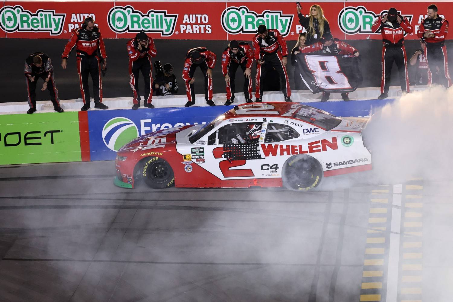 Jesse Love celebrates with a burnout as his crew cheers after winning the Timberland PRO 200 at Phoenix Raceway