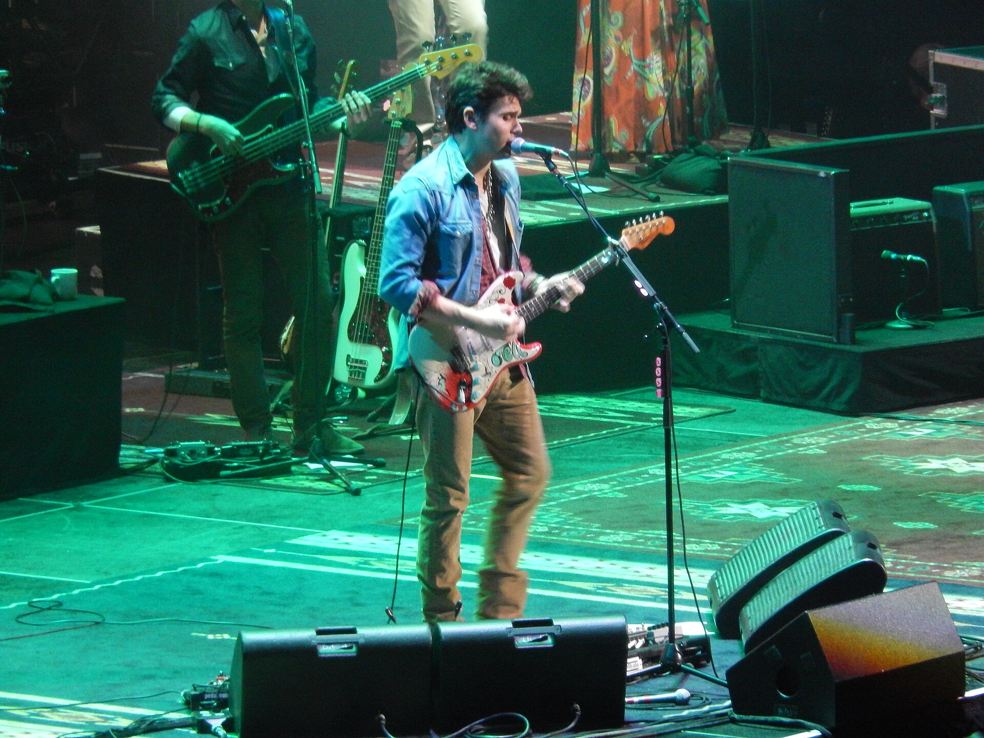 John Mayer playing guitar on stage