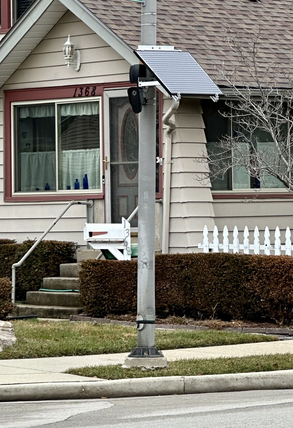 A Flock Safety license-plate-reading camera mounted on a pole in daylight