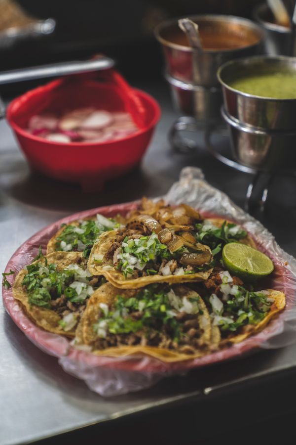 Plate of tacos with lime and salsas