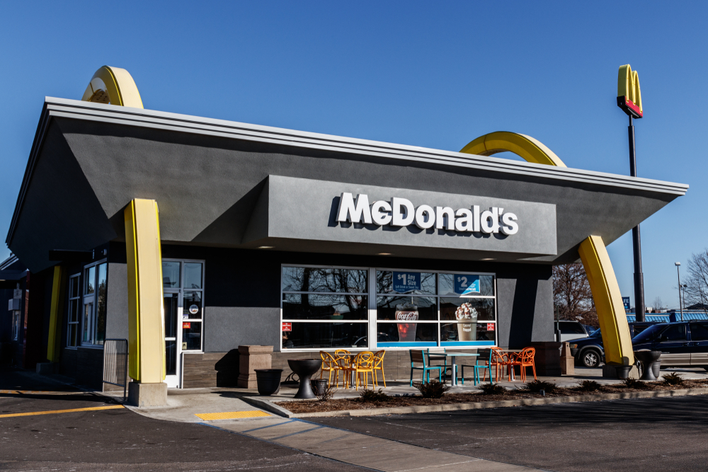 A McDonald's restaurant on a bright sunny day, with the golden arches visible above the entrance.