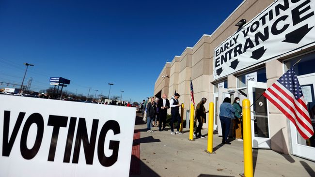 A voter casting a ballot at a polling place in bright daylight