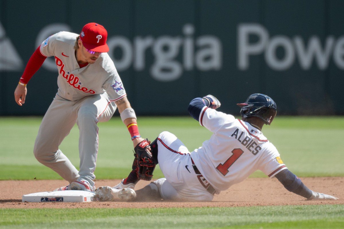 A Phillies infielder applies the tag to a Braves baserunner at second base