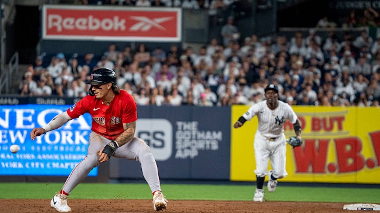 Red Sox and Yankees players in action under the lights at Yankee Stadium