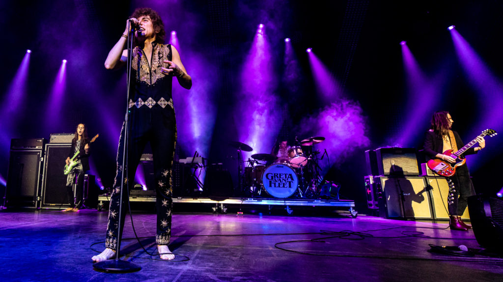 Greta Van Fleet performing live on stage.