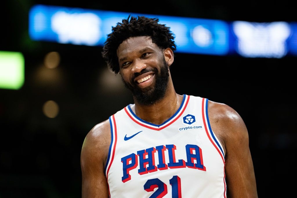 Joel Embiid in a Philadelphia 76ers uniform, smiling during a game
