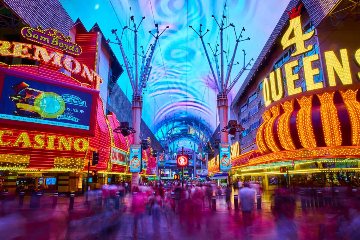 The Fremont Street Experience under the Viva Vision canopy, with the Fremont Casino and Four Queens lit up, steps from Neonopolis