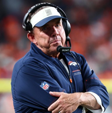 Denver Broncos head coach Sean Payton on the sideline wearing a headset
