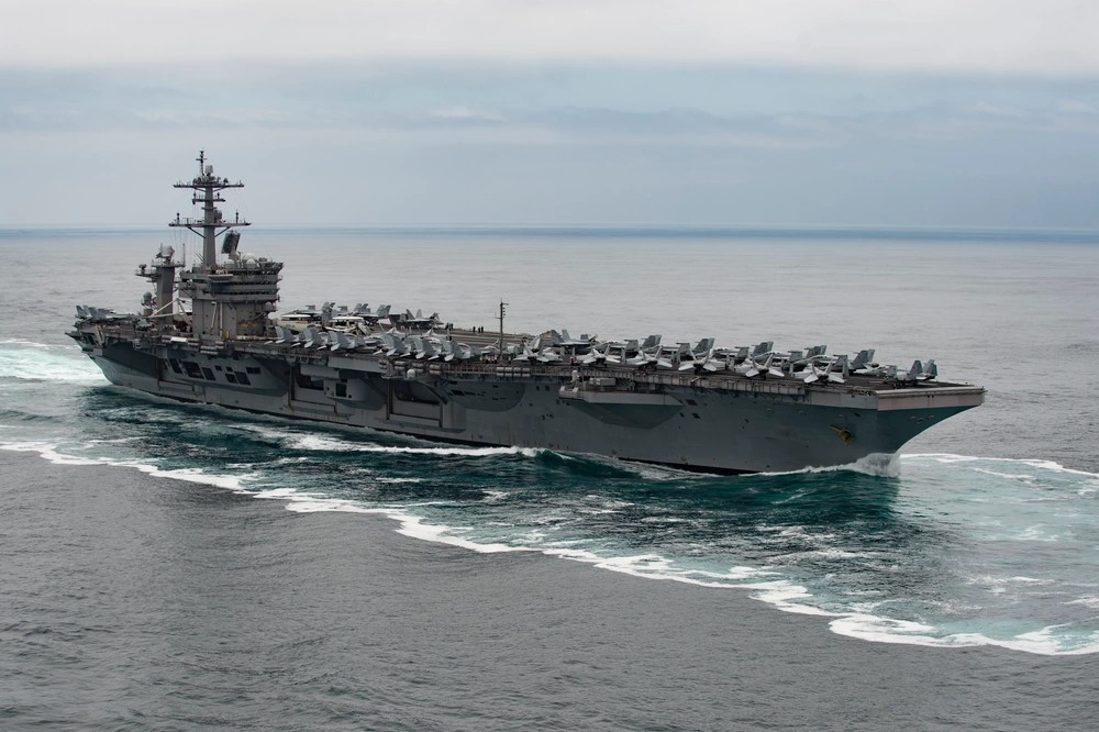 The USS Theodore Roosevelt (CVN 71) underway in daylight — the carrier strike group now heading to the Middle East