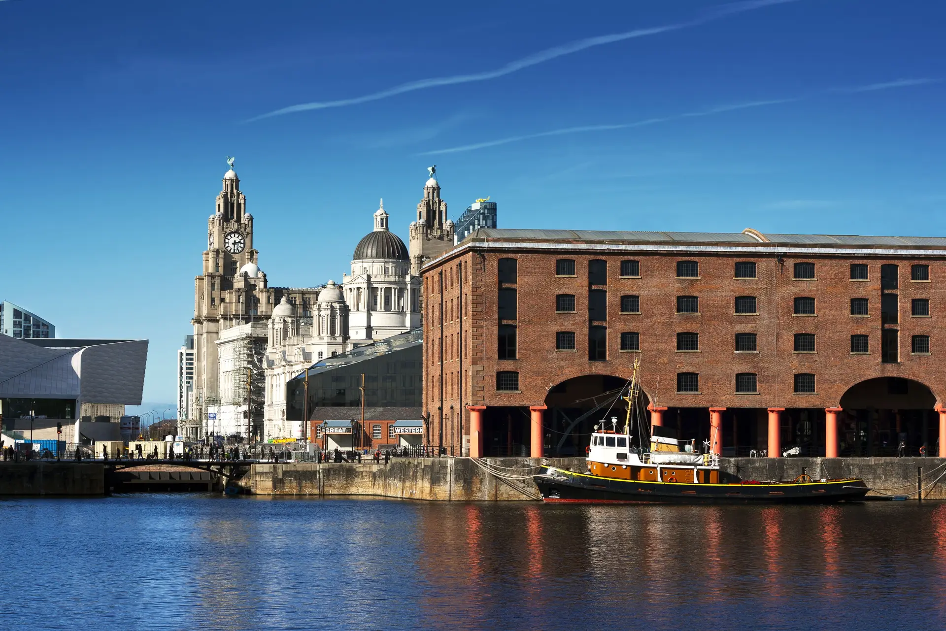 The Liverpool waterfront on the River Mersey on a bright day, with the Royal Liver Building and Albert Dock