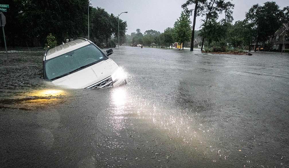 A flooded street in Texas with cars in high water.