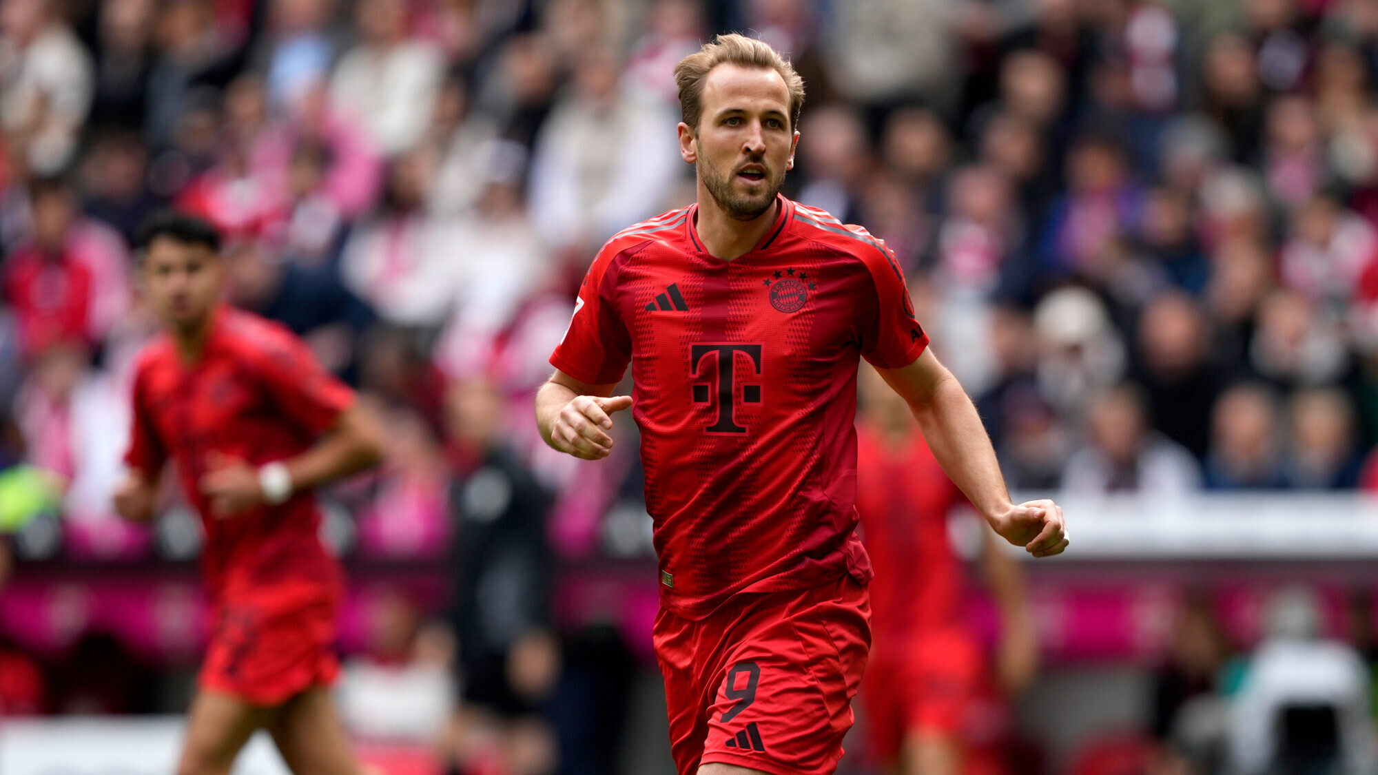 Harry Kane celebrates for Bayern Munich in the red home kit, number 9 on his shorts.