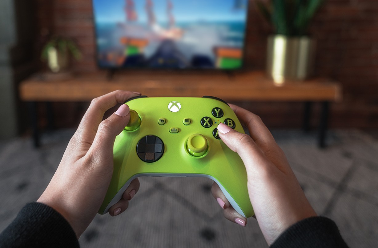 Player holding a lime-green Xbox controller while gaming.