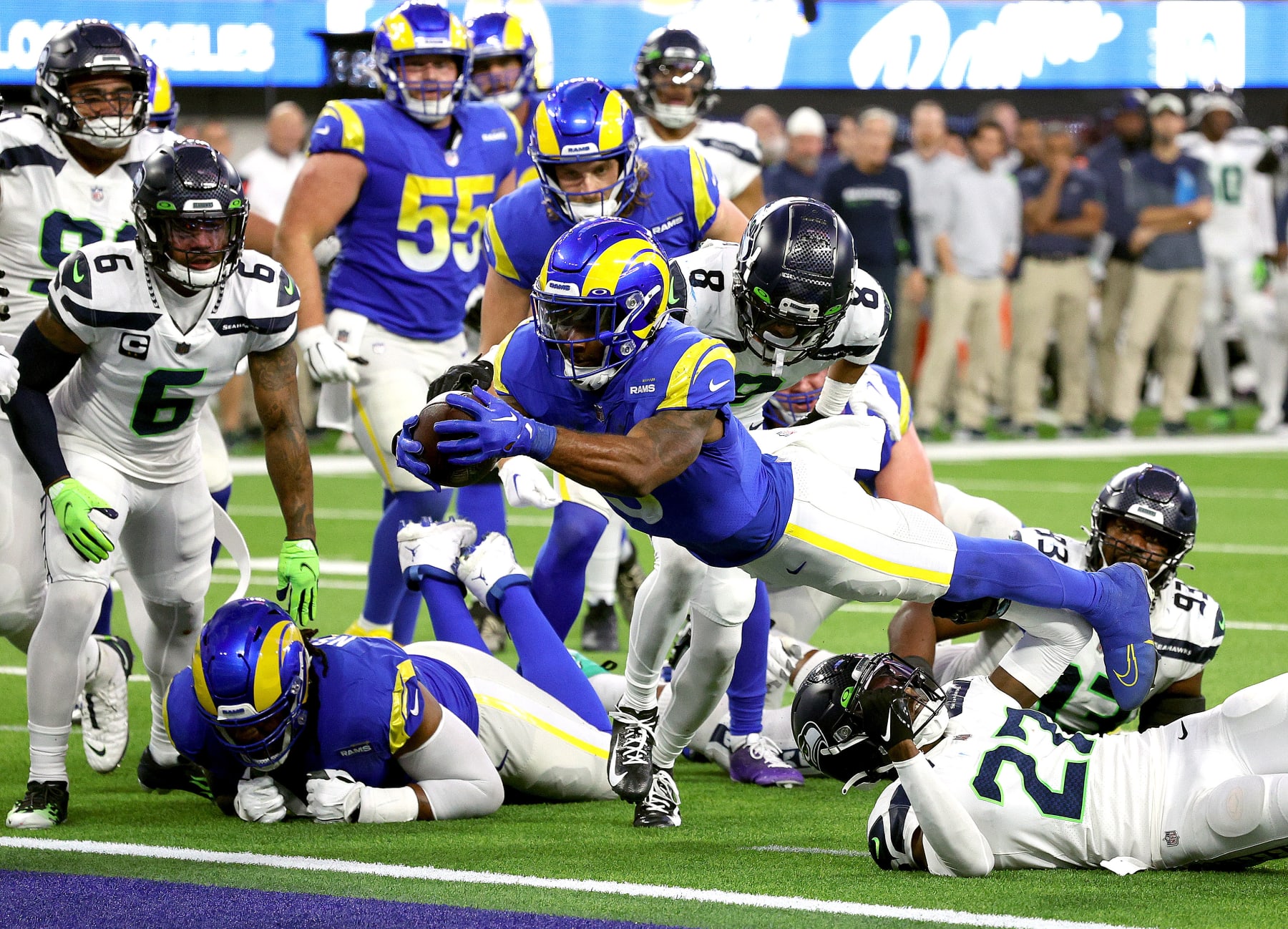 A Rams ball carrier dives through contact during a game.