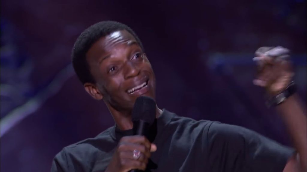 Stand-up comedian performing on stage in front of a live club audience