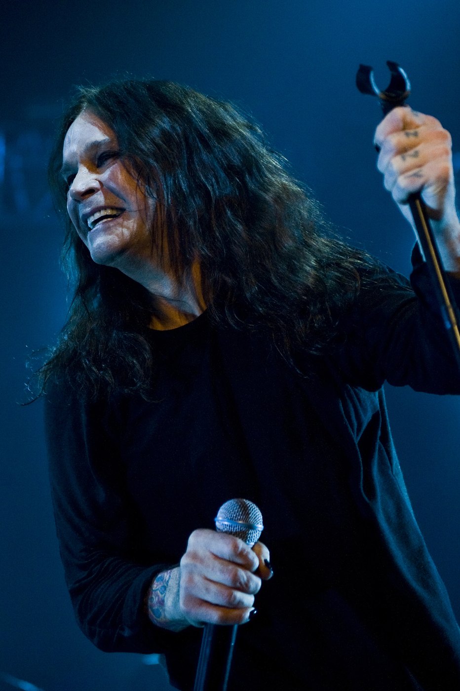Ozzy Osbourne performing on stage with a microphone