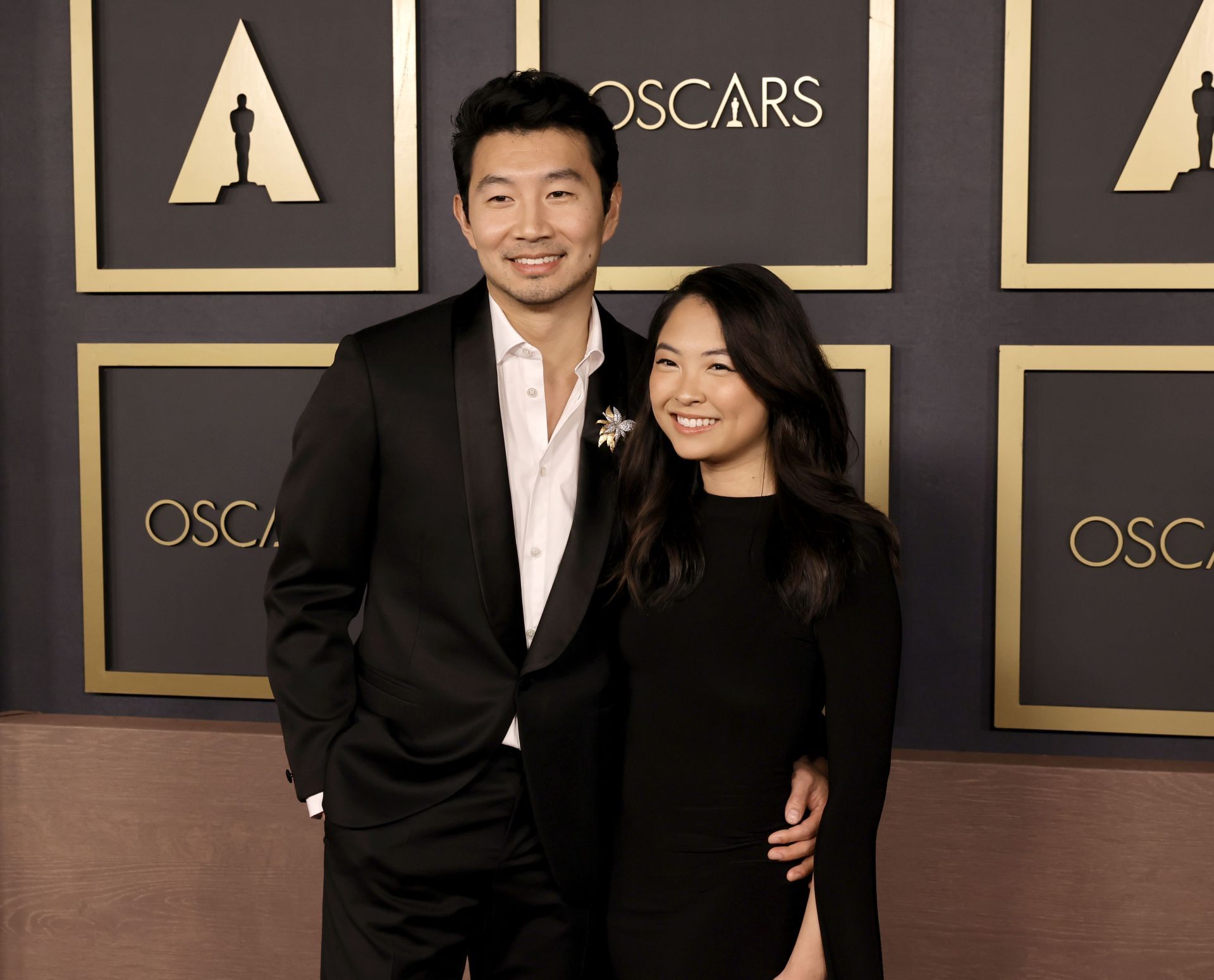 Simu Liu and Allison Hsu pose together at an Oscars event.