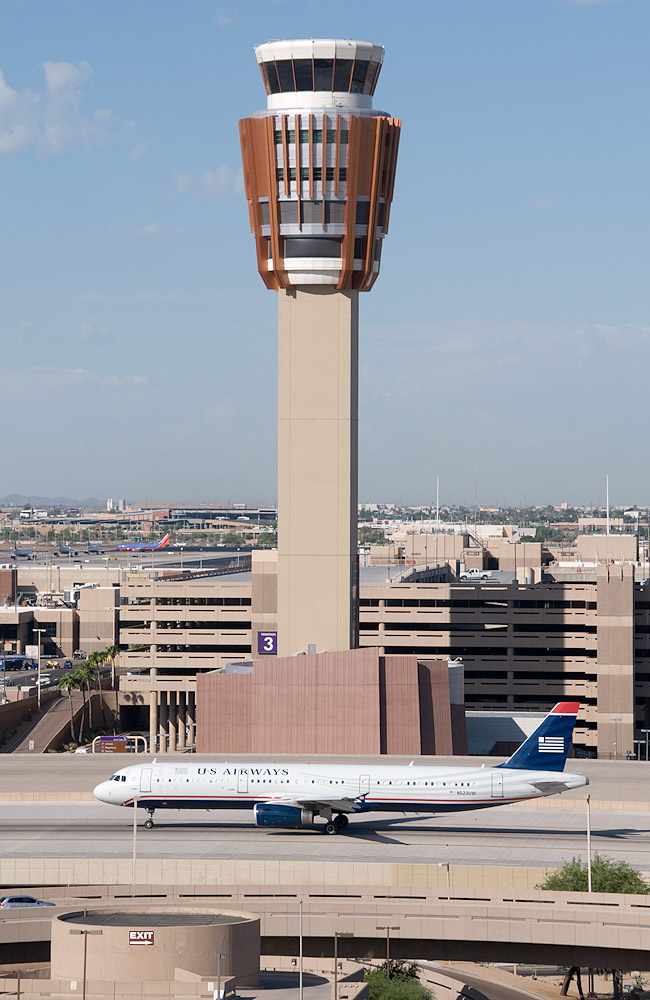 The control tower at Phoenix Sky Harbor with an airliner taxiing
