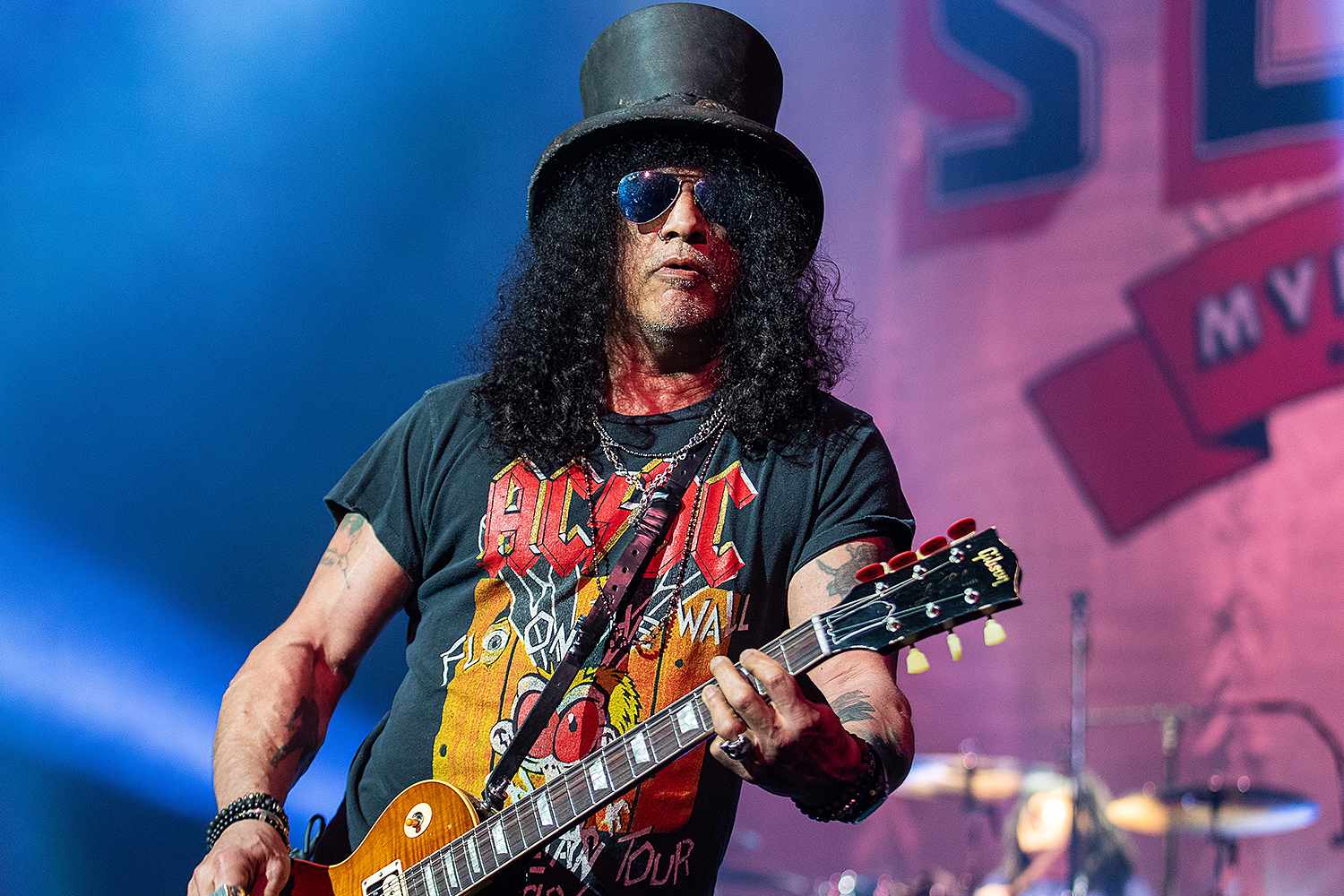 Slash performing live on stage in his top hat