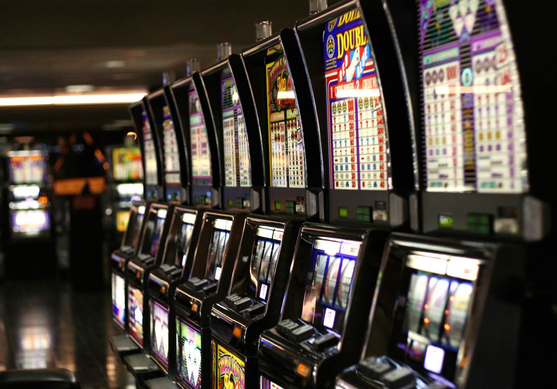 A row of classic slot machines glowing on a casino floor