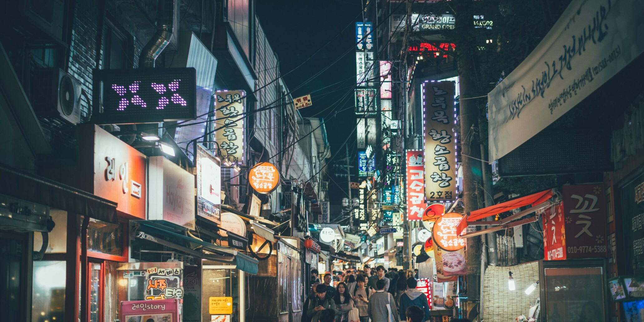 A Seoul street at night glowing with neon signs