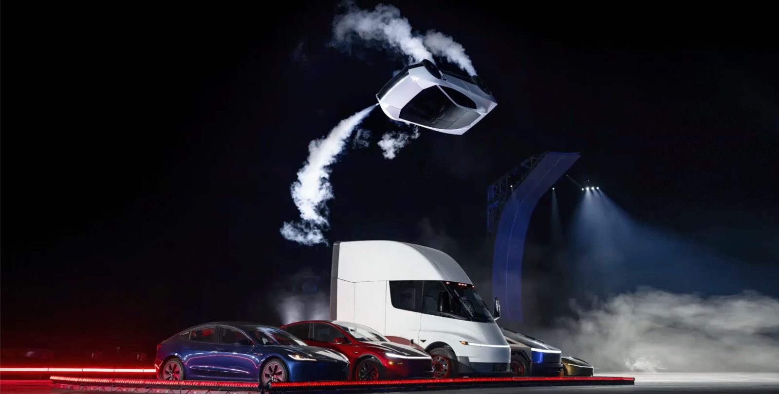 The redesigned Tesla Roadster upside down in mid-flip, vapor trailing from its cold-gas thrusters, above a Tesla Semi and the rest of the Tesla lineup at the McGregor reveal