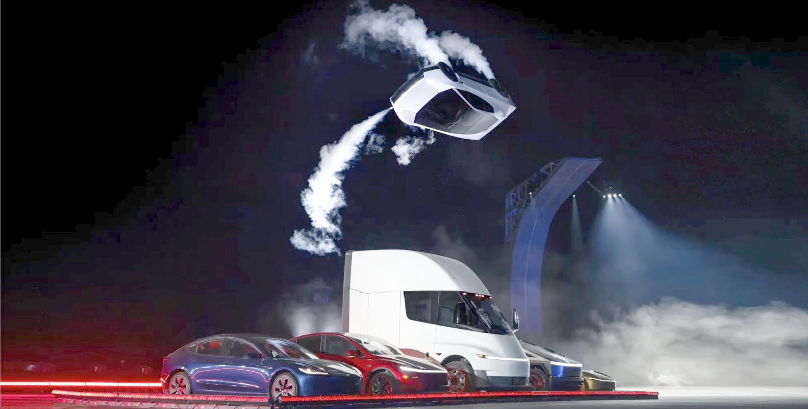 The redesigned Tesla Roadster flips upside down through the air on SpaceX cold-gas thrusters above a lineup of Tesla vehicles at its reveal in McGregor, Texas