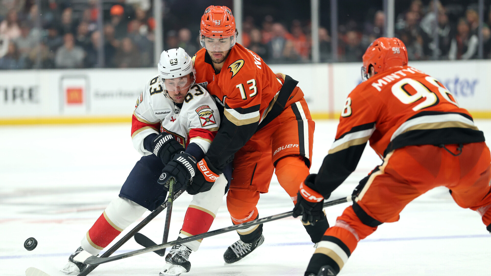 NHL forwards battling for the puck along the boards (file photo)